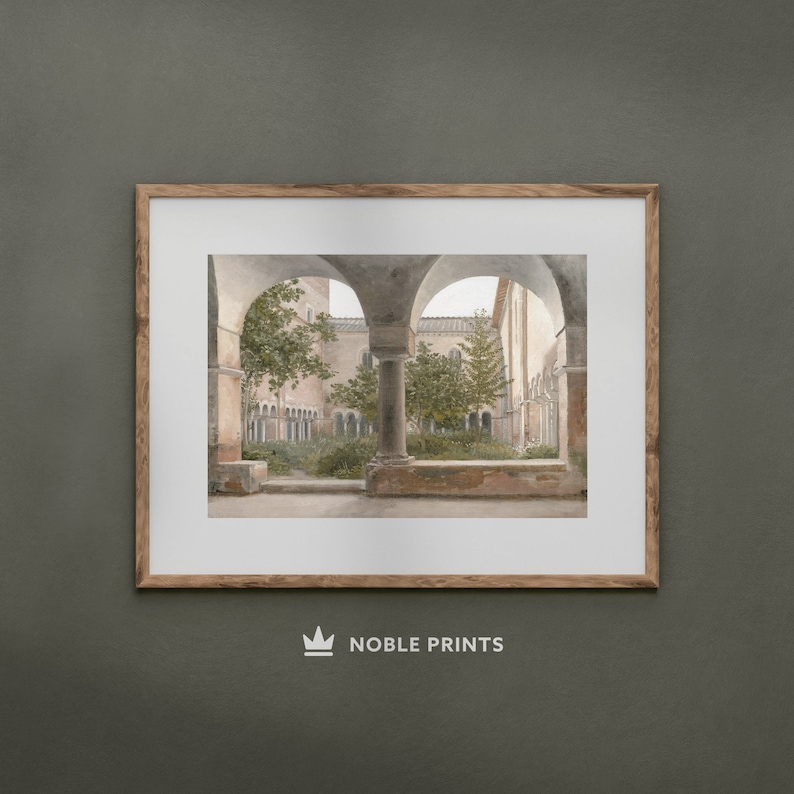May include: A framed photograph of a courtyard with arched walkways and lush greenery. The courtyard is surrounded by stone walls and columns, creating a sense of tranquility and peace.