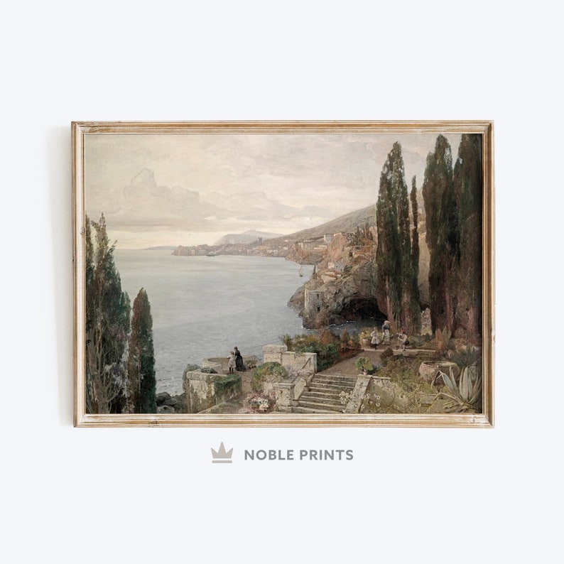 May include: A painting depicting a coastal scene with a town built into the hillside. The painting features a blue sea, a rocky coastline, and a group of people standing on a path leading down to the water. The painting is framed in a light wood frame.