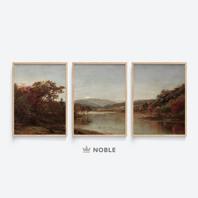 May include: A set of three framed landscape paintings depicting a river scene with trees and mountains in the background. The paintings are in a muted color palette of browns, greens, and blues.