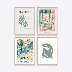 May include: Set of four framed art prints featuring the work of Henri Matisse. The prints include a green leafy design with the text "MATISSE" and "AIX EN PROVENCE", a colorful landscape scene, a green figure with a raised arm, and a window scene with the text "HENRI MATISSE" and "The Open Window, 1905".