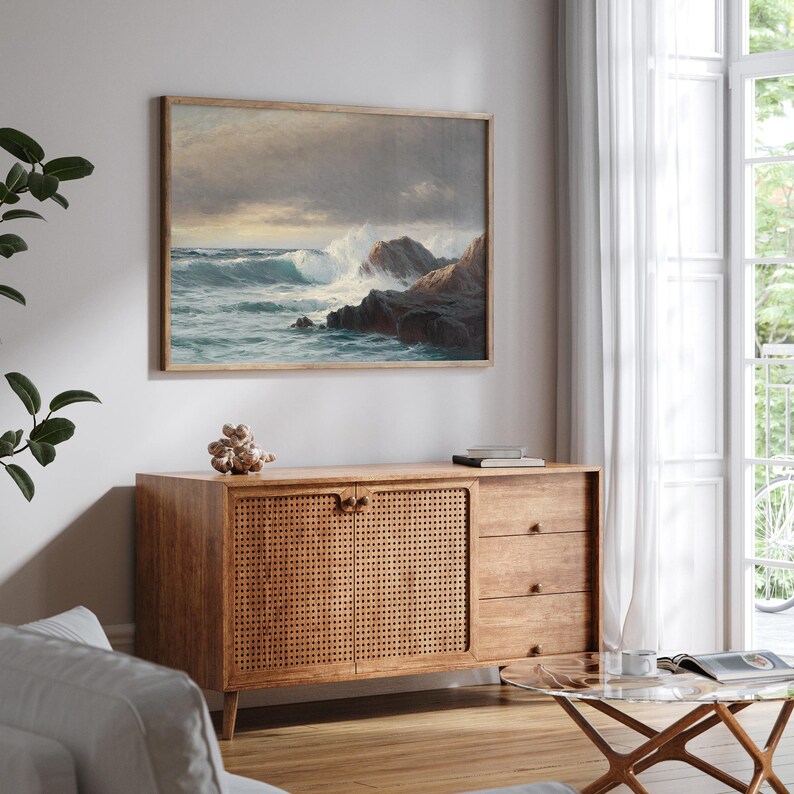 Puede incluir: Un armario de madera con un frente de rat&aacute;n tejido y tres cajones. El armario est&aacute; en un sal&oacute;n con un cuadro enmarcado de un paisaje mar&iacute;timo encima.
