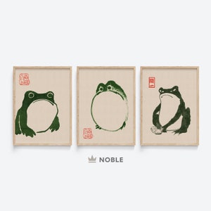May include: Three framed prints of green frogs in different poses. The top print features a frog with its mouth open, the middle print features a frog with its legs crossed, and the bottom print features a frog holding a bowl.