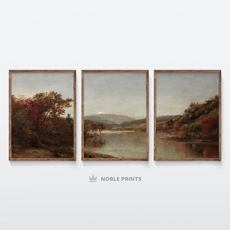 May include: A set of three framed landscape paintings depicting a river flowing through a valley with mountains in the background. The paintings feature a variety of trees, including some with red leaves, and a blue sky with clouds.