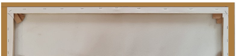 May include: A close-up of the back of a stretched canvas painting. The canvas is white and is stretched over a wooden frame. The frame is painted a light brown color. The canvas is secured to the frame with staples.