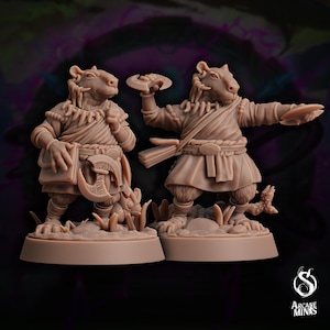 May include: Two brown painted miniature figurines of anthropomorphic rats wearing clothing and holding weapons. The rat on the left is holding a book and a small axe. The rat on the right is holding a throwing disc and a dagger. Both rats are standing on round bases.