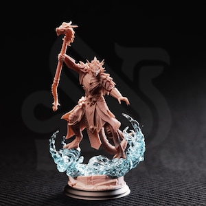 Può includere: Statuetta dettagliata di un personaggio umanoide simile a un drago, che tiene in mano un bastone con la testa di un drago. La figura è marrone chiaro, in piedi su una base con effetti d'acqua blu. Sfondo scuro.