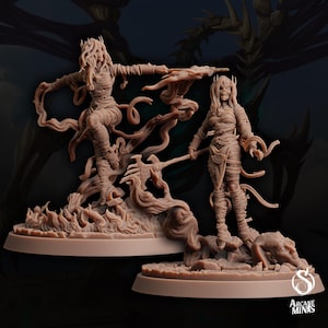 Puede incluir: Dos figuras en miniatura detalladas y pintadas a mano de mujeres con túnicas fluidas, de pie sobre bases con llamas. Las figuras están esculpidas en un color marrón claro.