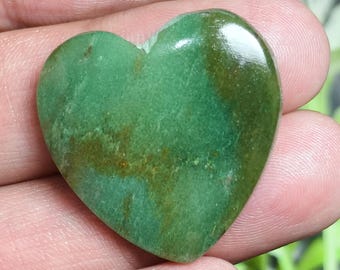 May include: A polished heart-shaped stone with a smooth, glossy surface. The stone features a variegated color palette of deep forest green and lighter emerald green tones, interspersed with patches of earthy brown mineral inclusions throughout.