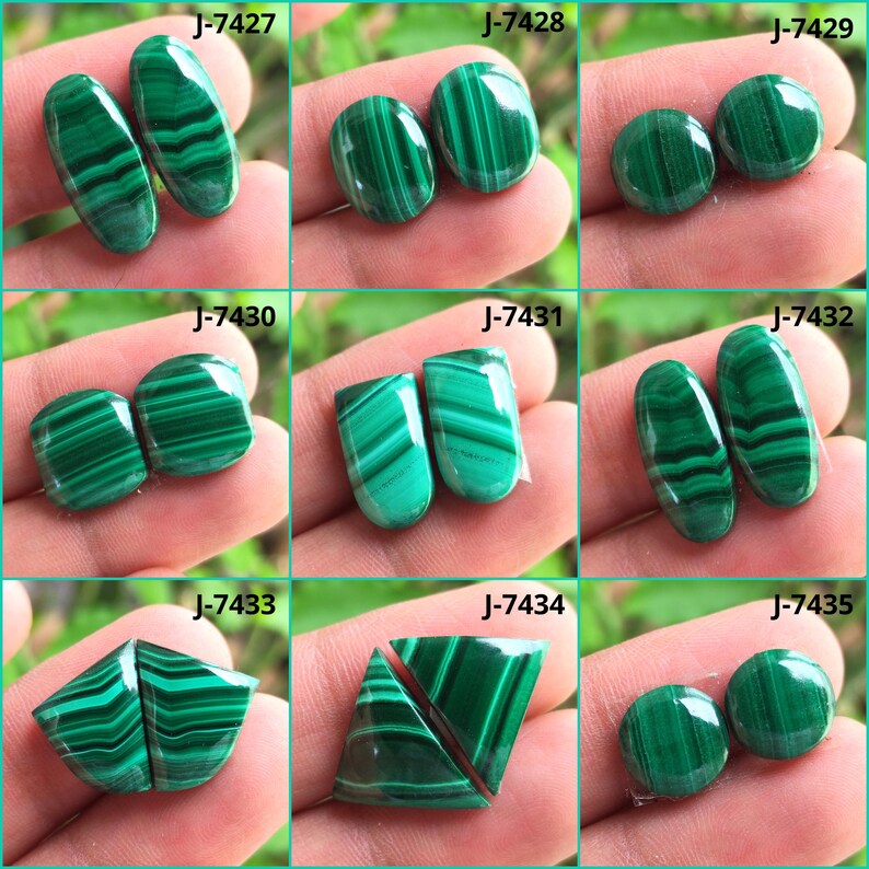 May include: A collection of polished malachite gemstones in various shapes, including oval, round, and rectangular. The stones display a vibrant green color with distinctive banded patterns. Each pair is labeled with a unique "J" number.