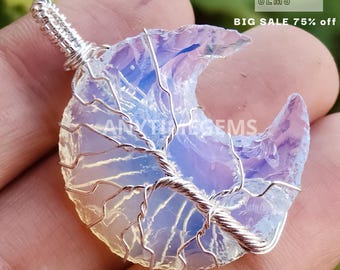 May include: A crescent moon shaped opal pendant with a silver wire tree design. The opal is translucent and has a rainbow of colors.