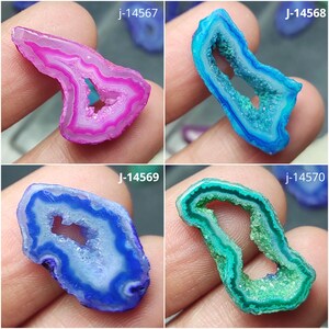 May include: Four agate slices with crystalline centers and banded edges. The top left is pink, top right is bright blue, bottom left is deep blue, and bottom right is green. Each slice is labeled with text: j-14567, J-14568, j-14569, and j-14570.