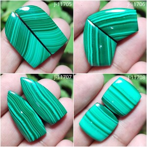 May include: Four pairs of polished malachite gemstones, each with unique shapes and patterns. The stones display a vibrant green color with darker green bands. Each pair is labeled with a "J" followed by a number.