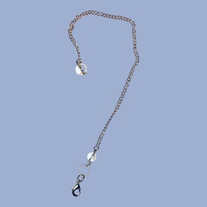 Könnte beinhalten: Eine goldene Kettenkette mit einem silbernen Verschluss und einer weißen Perle. Die Kette ist etwa 50 cm lang.