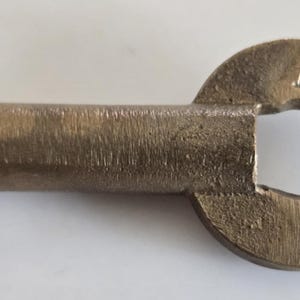 May include: A vintage brass key with a circular handle and a rectangular key bit. The handle is engraved with the letters "B.R. & R.R.". The key has a worn, antique appearance.