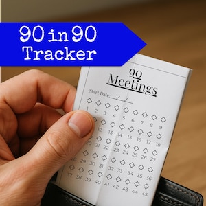 May include: A white 90 Meetings tracker card with a blue banner that reads "90 in 90 Tracker." The card has a series of numbered boxes for tracking progress. The card is held in a black wallet.