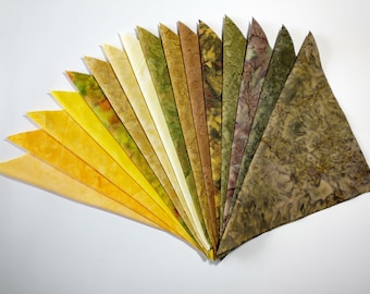 May include: A fan of 18 fabric swatches in shades of yellow, green, and brown. The swatches are arranged in a gradient from light yellow to dark brown.