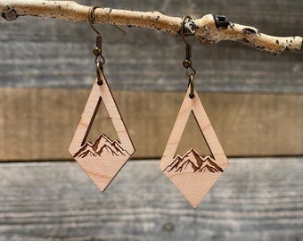Könnte beinhalten: Ein Paar Ohrringe aus Holz in Diamantform mit einem Bergketten-Design. Die Ohrringe sind aus hellem Holz gefertigt und haben eine natürliche Oberfläche.