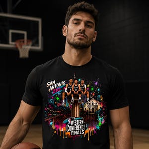 Pode incluir: T-shirt preto com um design gráfico colorido da equipa de basquetebol San Antonio Spurs. O design inclui o texto "San Antonio 210" e "Western Conference Finals". A imagem tem um estilo artístico vibrante com salpicos de cor.