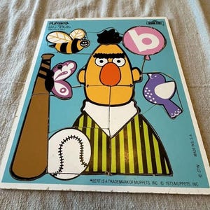 Può includere: Puzzle vintage di Bert di Sesame Street di Playskool. Il puzzle presenta Bert con una mazza da baseball, una palla da baseball e un palloncino con la lettera "B". Altre immagini includono un'ape, una farfalla e un uccello. Prodotto negli Stati Uniti.
