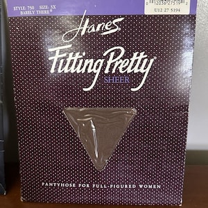 Könnte beinhalten: Eine Packung Hanes Fitting Pretty Sheer Strumpfhosen in Größe 3X. Die Verpackung ist lila mit weißen Punkten und dem Text "QUEENSIZE SHEER Reinforced Toe". Die Verpackung hat auch einen Barcode und den Text "PANTYHOSE FOR FULL-FIGURED WOMEN".