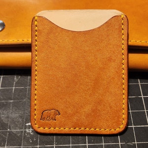 Cartera con 2 ranuras para tarjetas, con control deslizante para el pulgar.