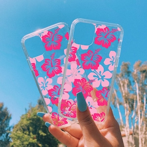 A clear phone case with tropical coconut girl vibes, it has a pink hawaiian hibiscus flower pattern printed on it.