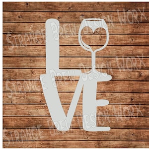 May include: A white vinyl stencil of the word "LOVE" with a wine glass design replacing the "O". The design is on a wood background.