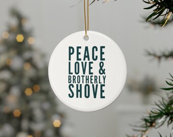 May include: White ceramic Christmas ornament with the text "Peace Love & Brotherly Shove" in dark teal lettering.
