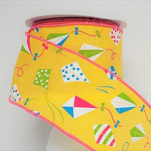 2 1/2 inch red, green, blue and white decorate high flying kites on a yellow background ready to decorate for spring and summer.