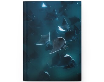 May include: A school of manta rays swims in a dark blue ocean. The rays are silhouetted against the light from above, creating a dramatic image.