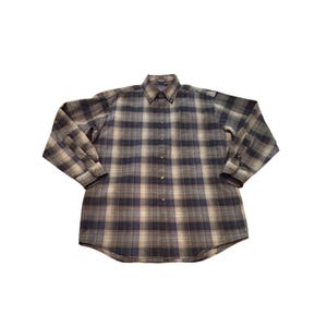 以下が含まれることがあります： 青、グレー、ベージュの色合いのチェック柄の長袖ボタンダウンシャツ。 シャツはボタンダウンカラーとボタン付きの袖口が付いています。 生地は中程度の重さのようです。