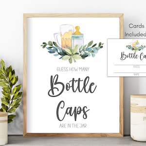 May include: A framed sign with the text "Guess How Many Bottle Caps Are in the Jar." A smaller card with the words "Bottle Caps" and spaces for "Guess" and "Name" is included. The design features watercolor illustrations of a beer mug, baby bottle, and greenery.