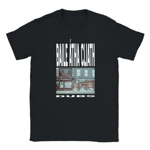 May include: Black t-shirt featuring the text "BAILE ÁTHA CLIATH" in white, above a color image of a street scene. The word "DUBS" is printed in white at the bottom of the image.