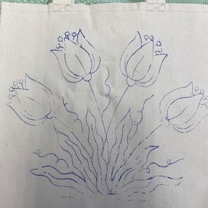 May include: A white canvas tote bag with a blue outline of three tulips and leaves.