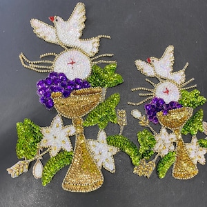 May include: Two embroidered patches featuring religious symbols. Each patch includes a gold chalice, a white dove, purple grapes, and green leaves. The patches are embellished with sequins and beads, creating a detailed and ornate design.