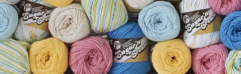 May include: A variety of colorful yarn balls in different colors, including white, blue, yellow, pink, and green. The yarn is labeled "Sugar'n Cream" and is made by Lily.