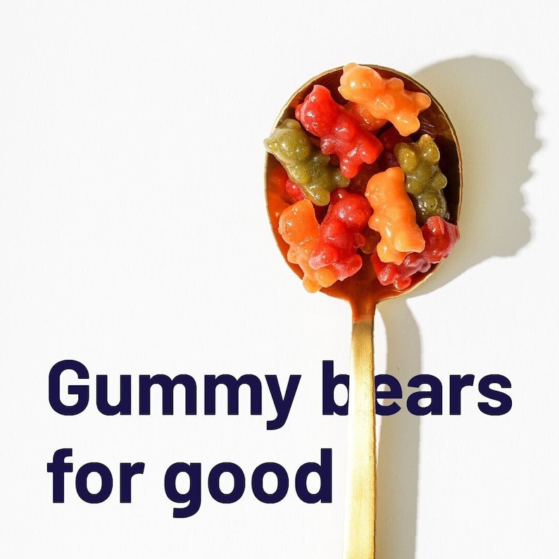 May include: A gold spoon filled with colourful gummy bears. The text "Gummy bears for good" is written below the spoon.