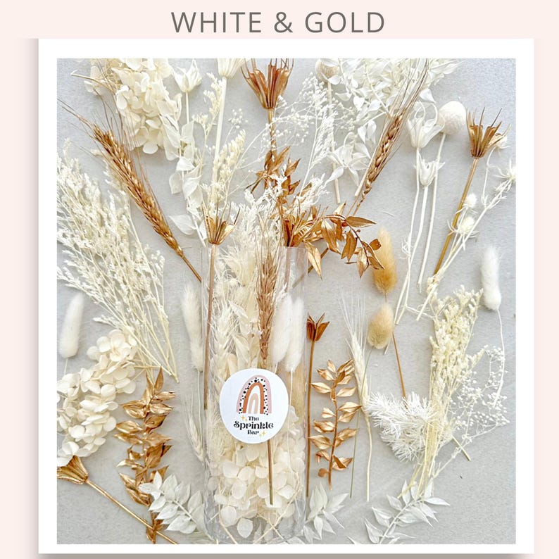 May include: A clear plastic bag filled with dried white and gold flowers. The bag is labeled "The Sprinkle Bar".