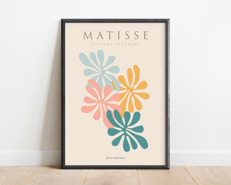 May include: A framed print of a Matisse artwork featuring colorful cut-out paper shapes in shades of blue, pink, and yellow. The title "MATISSE PAPIERS DECOUPES" and the artist's name "Henri Matisse" are printed below the artwork.