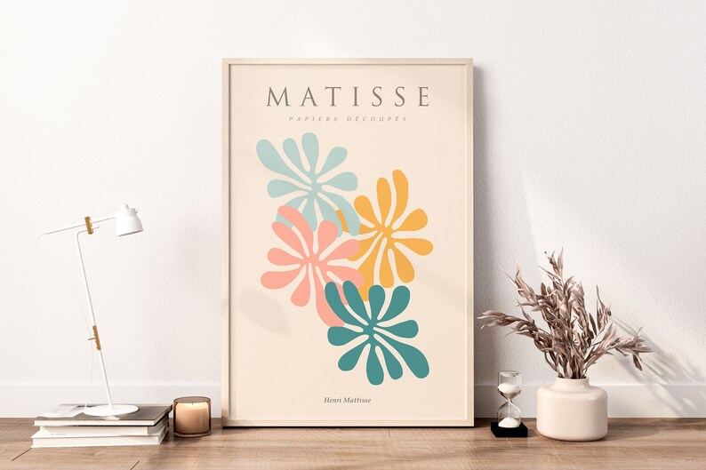 May include: A framed print with a beige background featuring a Matisse-inspired design of four colorful abstract flowers in shades of teal, pink, yellow, and orange. The text "MATISSE PAPIERS DECOUPES Henri Matisse" is printed below the flowers.