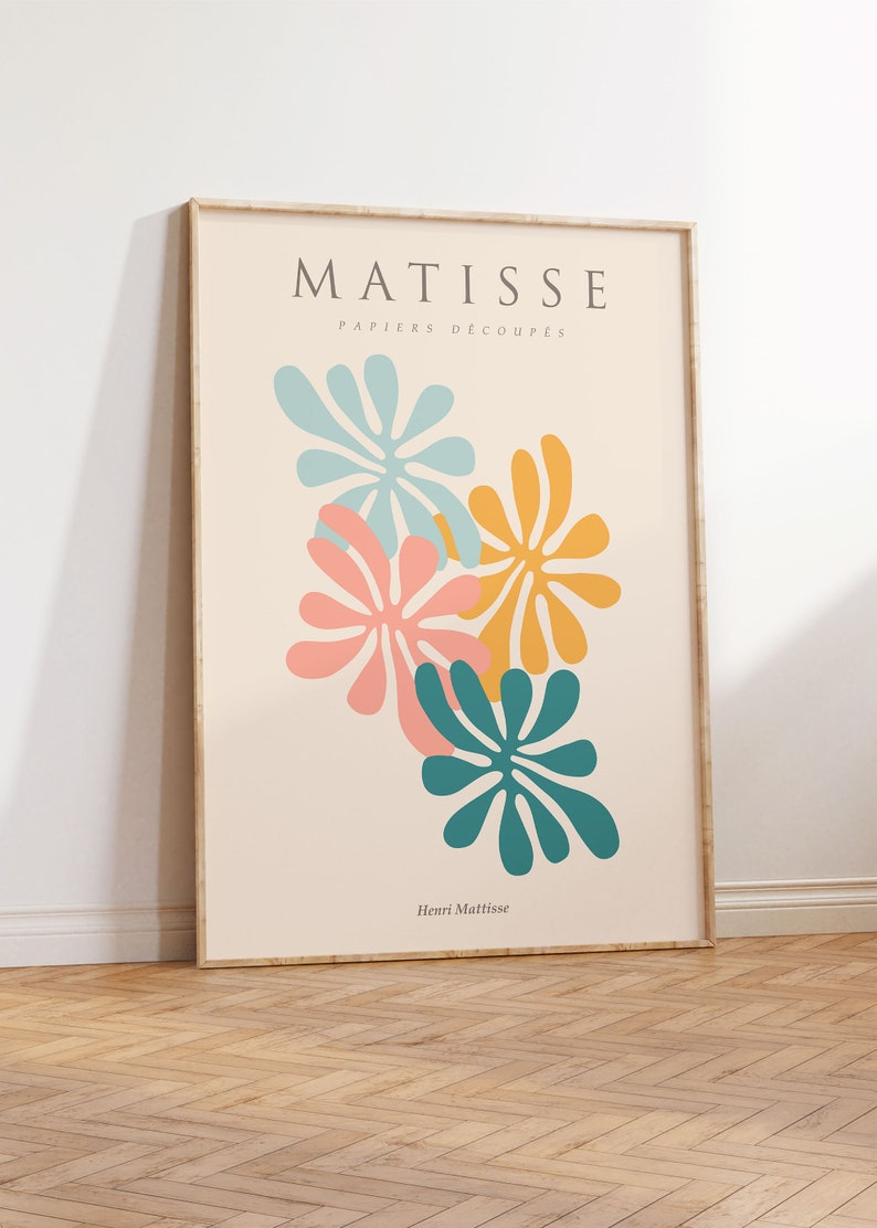 May include: A framed print of a Matisse artwork featuring colorful cut-out paper shapes in shades of blue, pink, yellow, and green. The title "MATISSE PAPIERS DECOUPES" and the artist's name "Henri Matisse" are printed below the artwork.