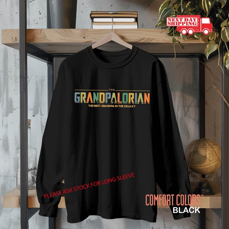 May include: Black long-sleeve shirt with a colorful graphic that says "The Grandpalorian The Best Grandpa in the Galaxy".