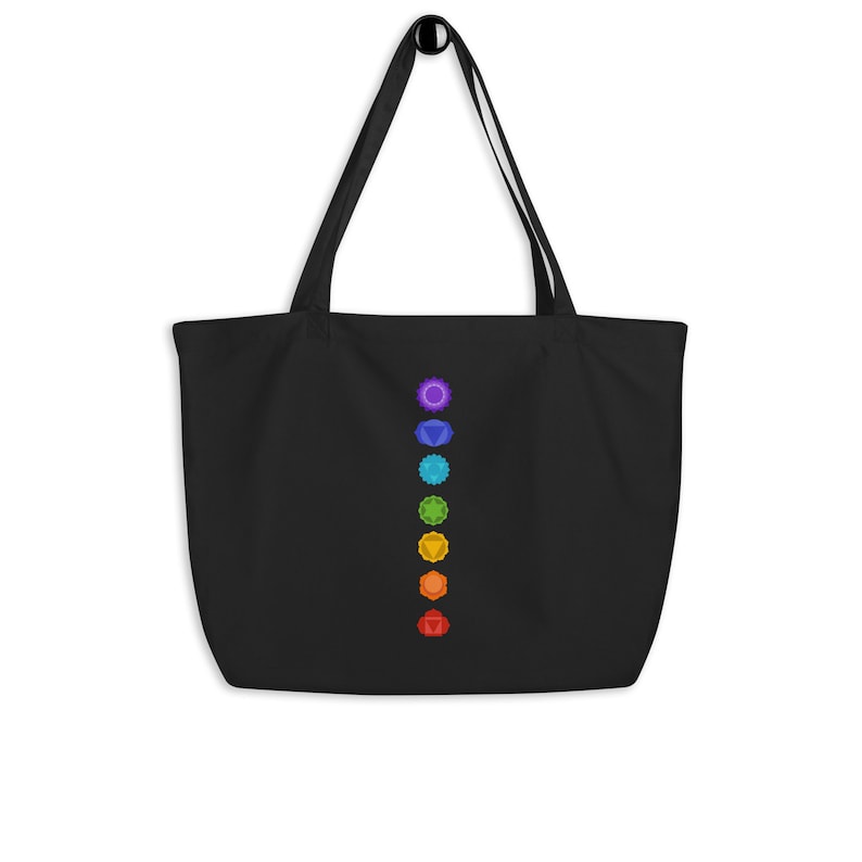 Pode incluir: Sacola tote preta com uma fileira vertical de sete s&iacute;mbolos de chakras coloridos.