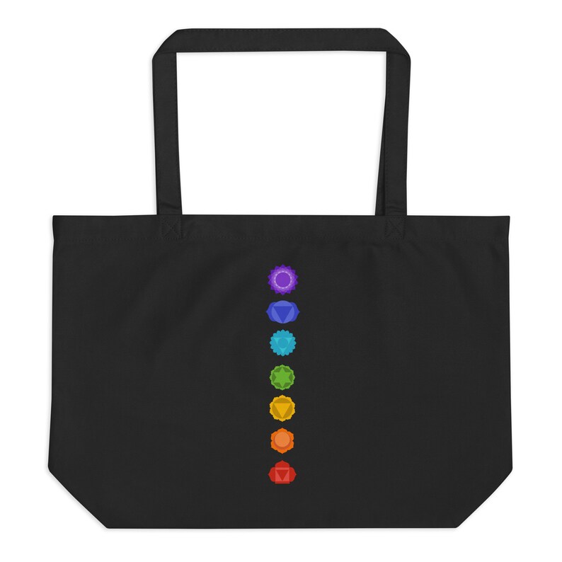 Pode incluir: Sacola tote preta com uma fileira vertical de sete s&iacute;mbolos de chakras coloridos.
