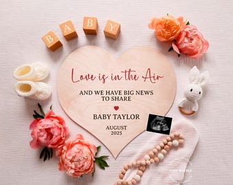 May include: A wooden heart-shaped sign with the text "Love is in the air and we have big news to share" and "Baby Taylor August 2025". The sign is surrounded by pink flowers, baby booties, a crocheted bunny rattle, and a sonogram image.