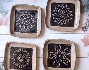 A set of 4 small handmade square ceramic plates.