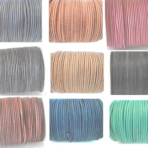 May include: A collection of nine spools of round leather cord in various colours including black, tan, pink, dark brown, light brown, charcoal, reddish-brown, navy blue, and bright green, arranged in a grid pattern for jewellery making.
