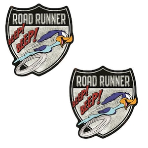 May include: Two vintage-style metal signs featuring the Road Runner cartoon character. Each sign is shaped like a shield and features the Road Runner running with the words "Road Runner" and "Beep! Beep!" in red and white text.
