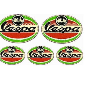 May include: Five oval stickers with a vintage design featuring the word "Vespa" in black lettering on a red and white background with a green border. The stickers feature a black and white silhouette of a Vespa scooter.