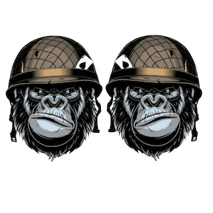 Könnte beinhalten: Zwei schwarze Gorillaköpfe, die Militärhelme mit Tarnmuster tragen. Die Helme haben ein goldenes Band und ein Einschussloch. Die Gorillas haben einen ernsten Ausdruck.